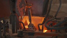 Raw materials pouring into a Glass melting furnace in a glass production facility