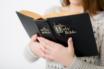 A teen girl reading a Bible 