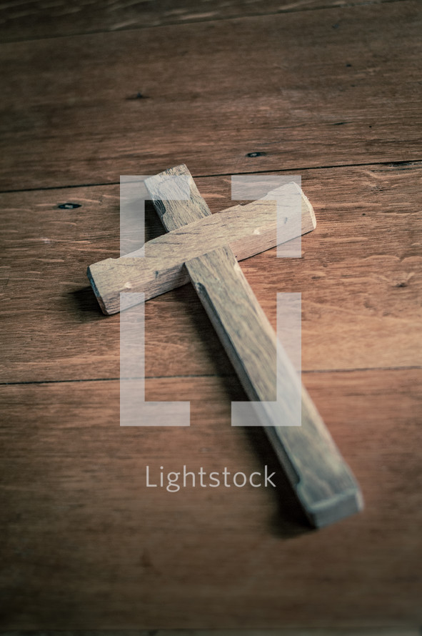 Wooden cross on a wooden table.