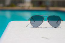 sunglasses on a pool deck 