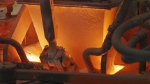 Raw materials pouring into a Glass melting furnace in a glass production facility
