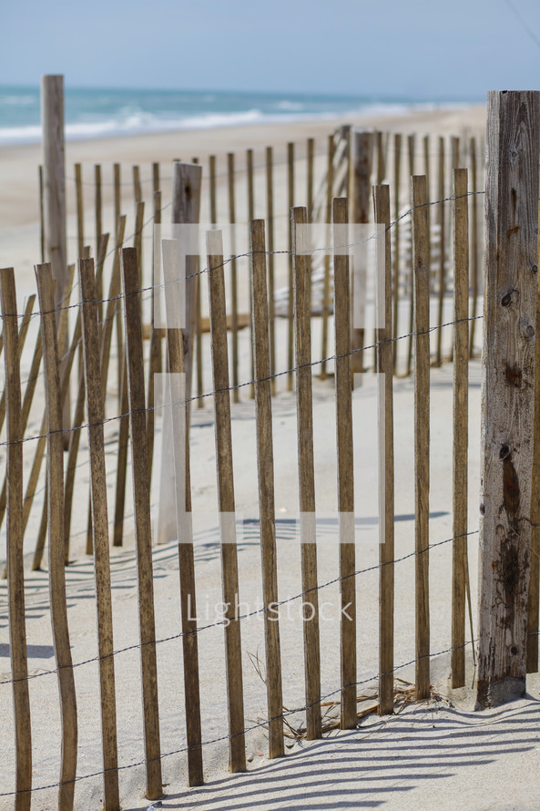 Reed fence on beach at ocean.