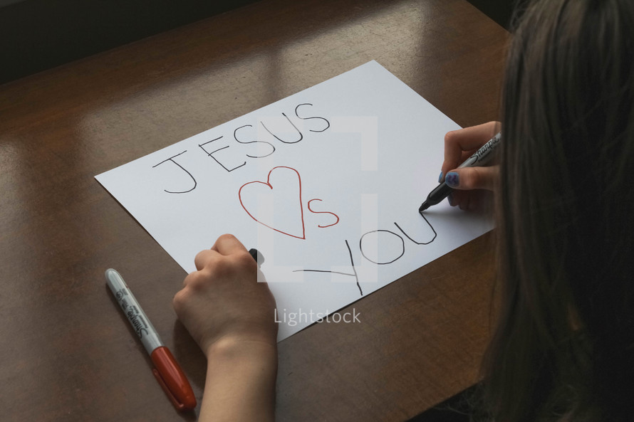 Girl writing Jesus loves you