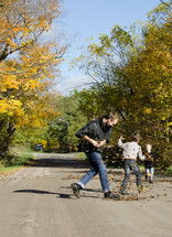 father and son playing with fall leaves 