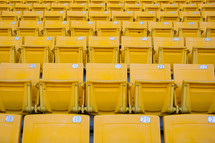 rows of yellow seats in a stadium 