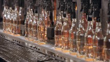 Glass bottles production. Glowing red hot glass bottles in a production facility