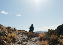 a man sitting in a desert 