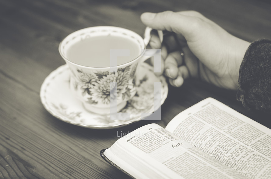 woman reading a Bible and tea cup