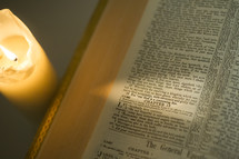 Burning candle next to a Bible open to Hebrews 13.