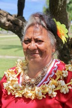 a woman wearing a lei with flowers in her hair 