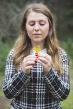 young woman holding small spring flowers