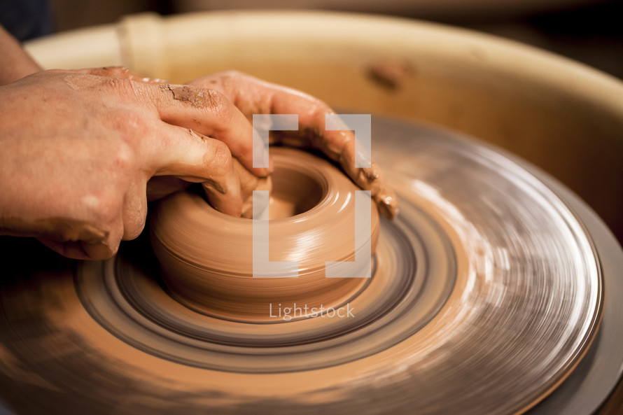 hand on clay on a potter's wheel 