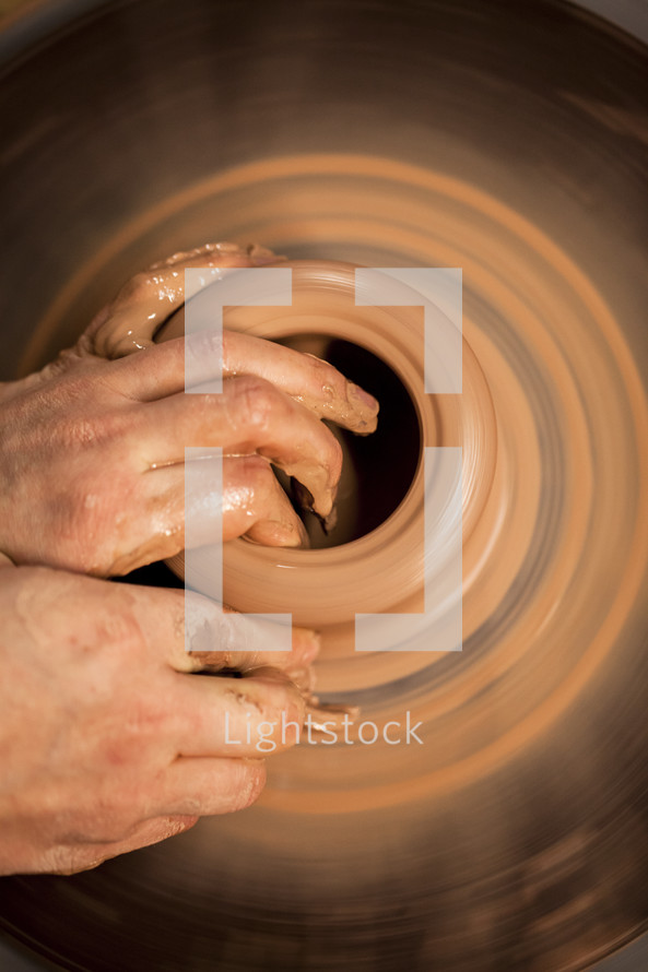 hand on clay on a potter's wheel  