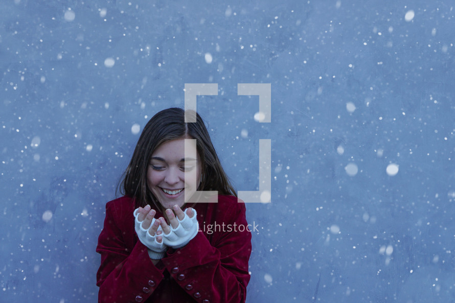 a teen girl catching snowflakes 
