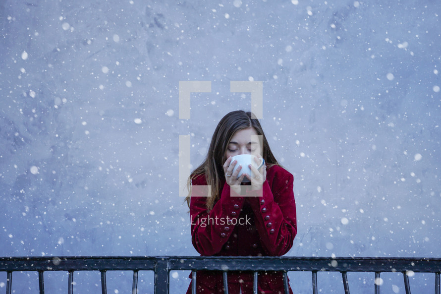 a teen girl drinking a mug in the snow 
