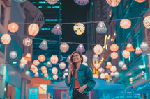 woman standing under paper lanterns 