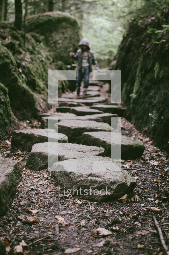 A girl walks along a stepping stone path