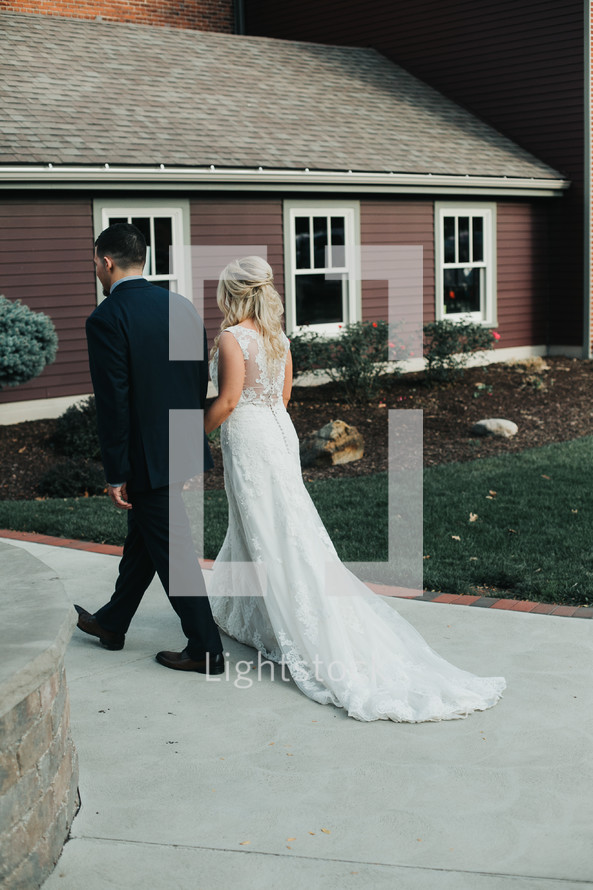 bride and groom walking holding hands 