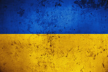 Grungy and damaged wall painted with blue and yellow paint like Ukrainian flag