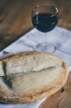 A loaf of bread and a glass of wine on a table