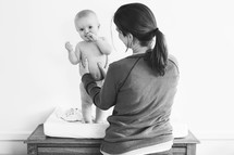 a mother and infant at a changing table 