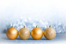 row of gold Christmas ornaments