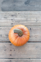 orange pumpkin on a wood deck 