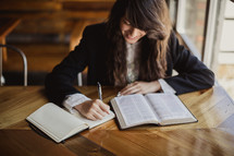 woman reading a Bible and taking notes 