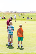 father and sons on the golf course 