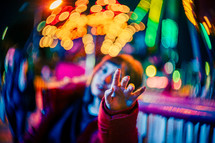 woman pointing to bright bokeh lights 