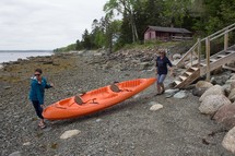 carrying a canoe on a beach in Maine 