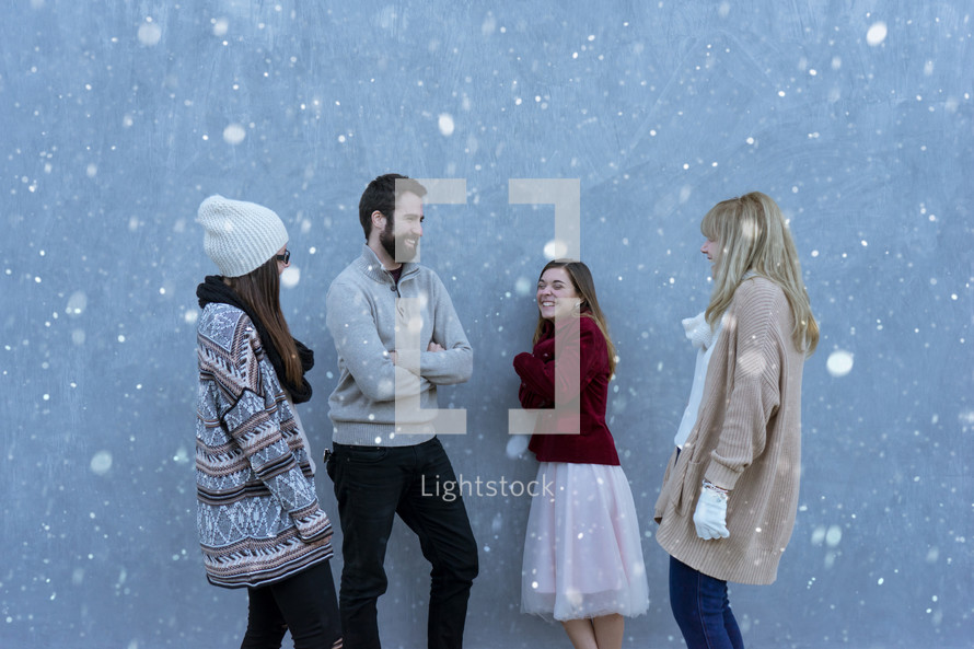 friends standing outdoors talking in the snow 