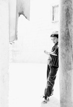 A boy leans against a wall