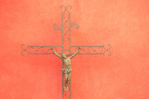Iron crucifix against a textured orange wall