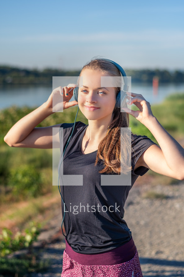 teen girl wearing headphones on a jog 
