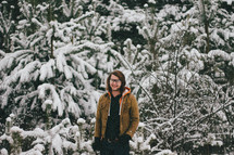 man standing in a snow covered forest 