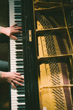 hands playing piano keys 