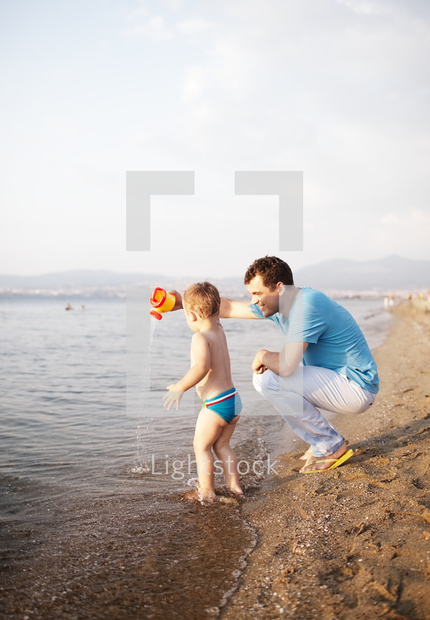 Young father playing with his son at the beach