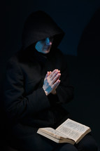 Woman Hands Praying With A Bible In Dark
