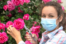 a woman in a garden wearing a face mask 