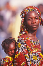 African woman and child in traditional clothing with child on her back