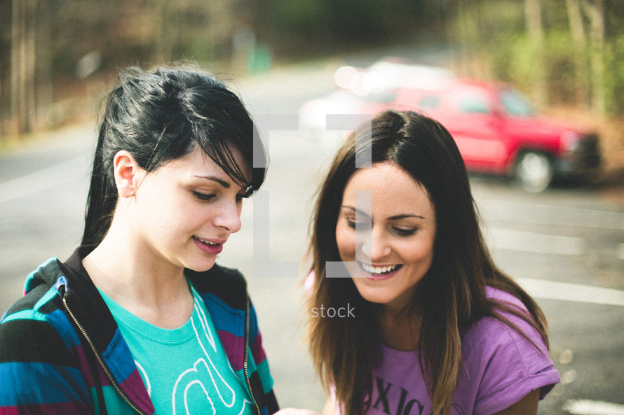 two young women talking outdoors 