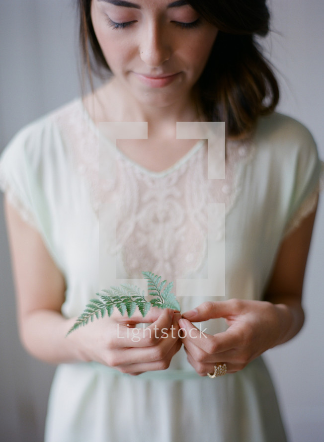 woman holding a fern 