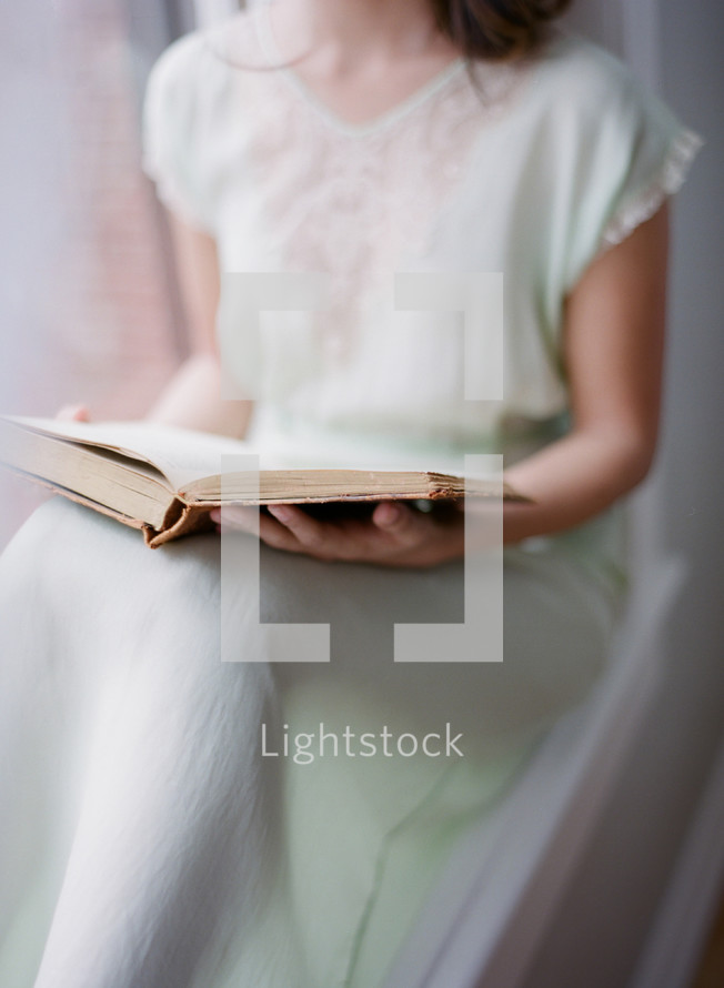 woman in a silk dress reading 