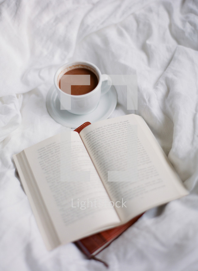 Bible, journal, and mug on a bed 