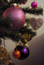pink and purple Christmas ornaments on a Christmas tree 