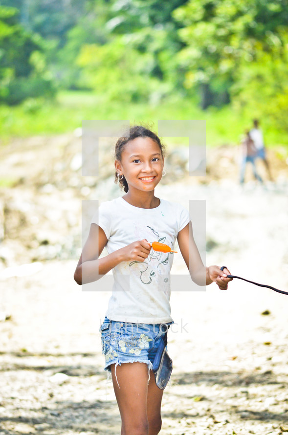 girl child holding a leash and eating a popsicle