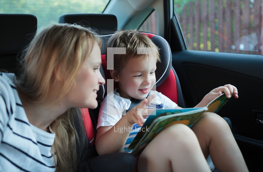 Mother and son with a book in the car