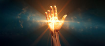  Hand with glowing cross with rays of light against blue sky with dark background