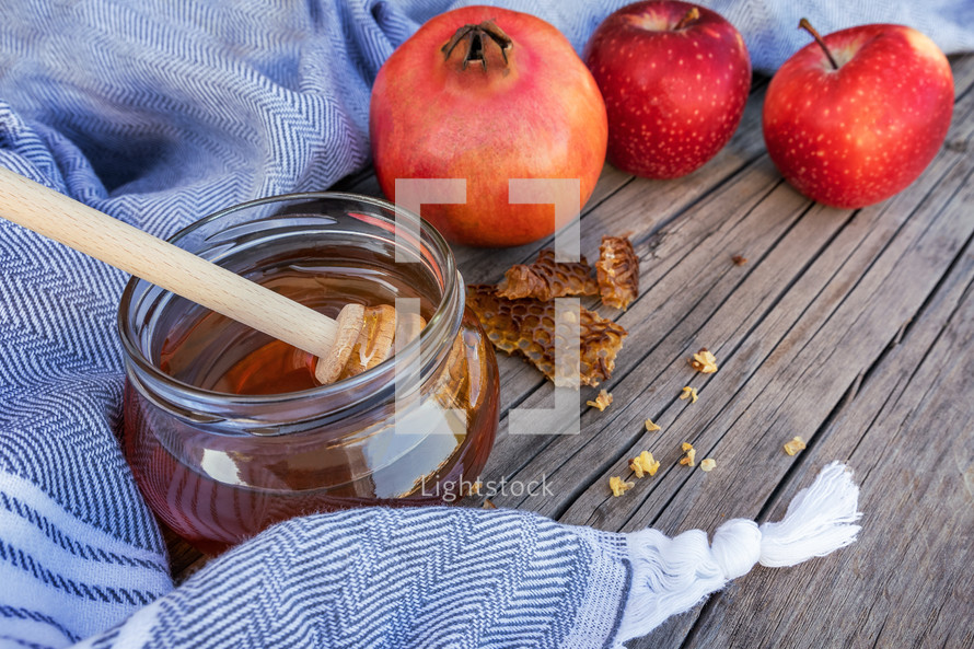 Jewish National Holiday. Rosh Hashana with honey, apple and pomegranate on wooden table.